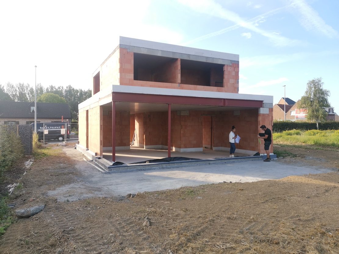 Aanleg gescheiden rioleringssysteem met oranje PVC-buizen tijdens de ruwbouwfase van een nieuwbouwwoning.