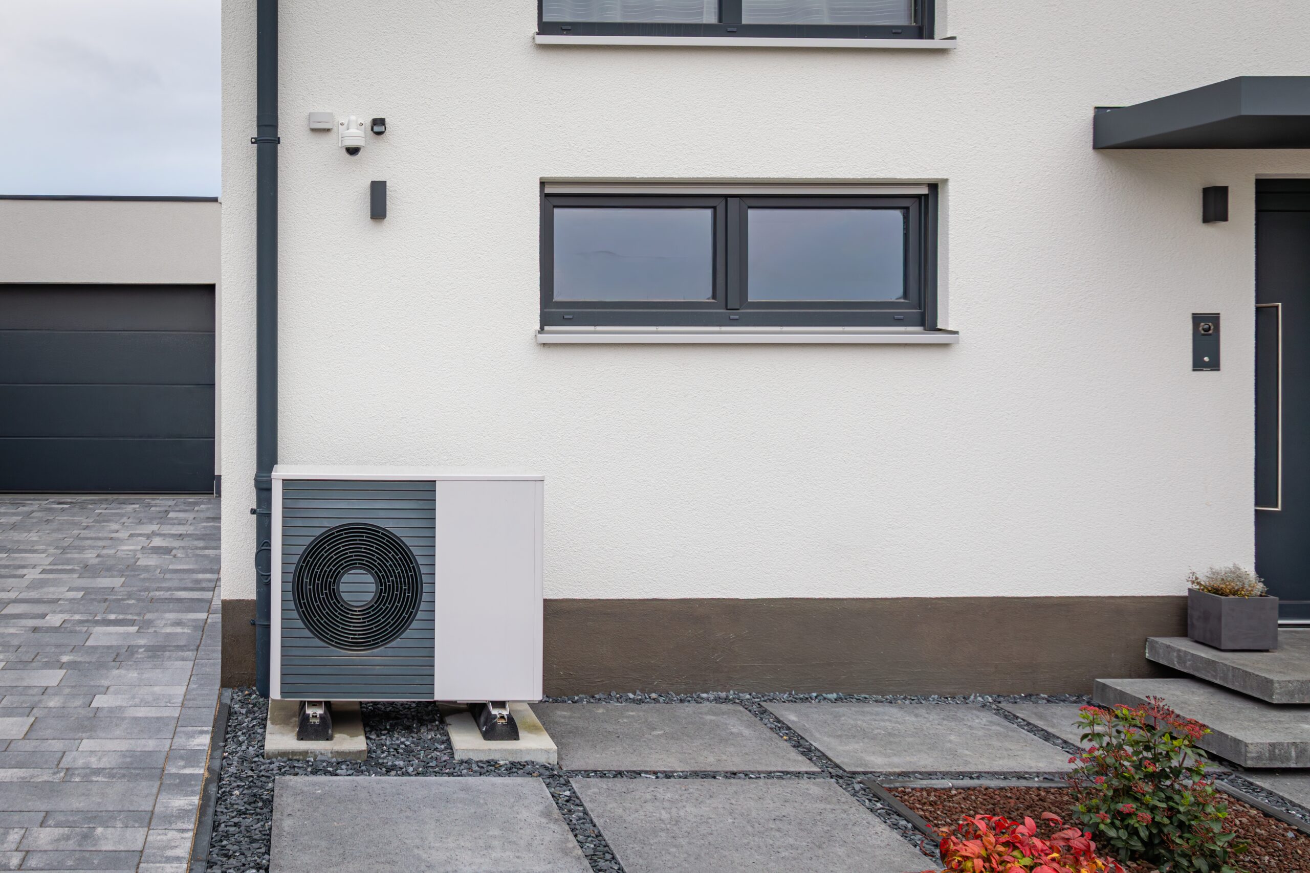 Lucht-water warmtepomp geplaatst tegen de gevel van een moderne nieuwbouwwoning