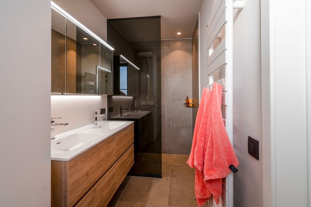 Moderne badkamer met grote vochtbestendige vloertegels, een inloopdouche en een houten badkamermeubel.
