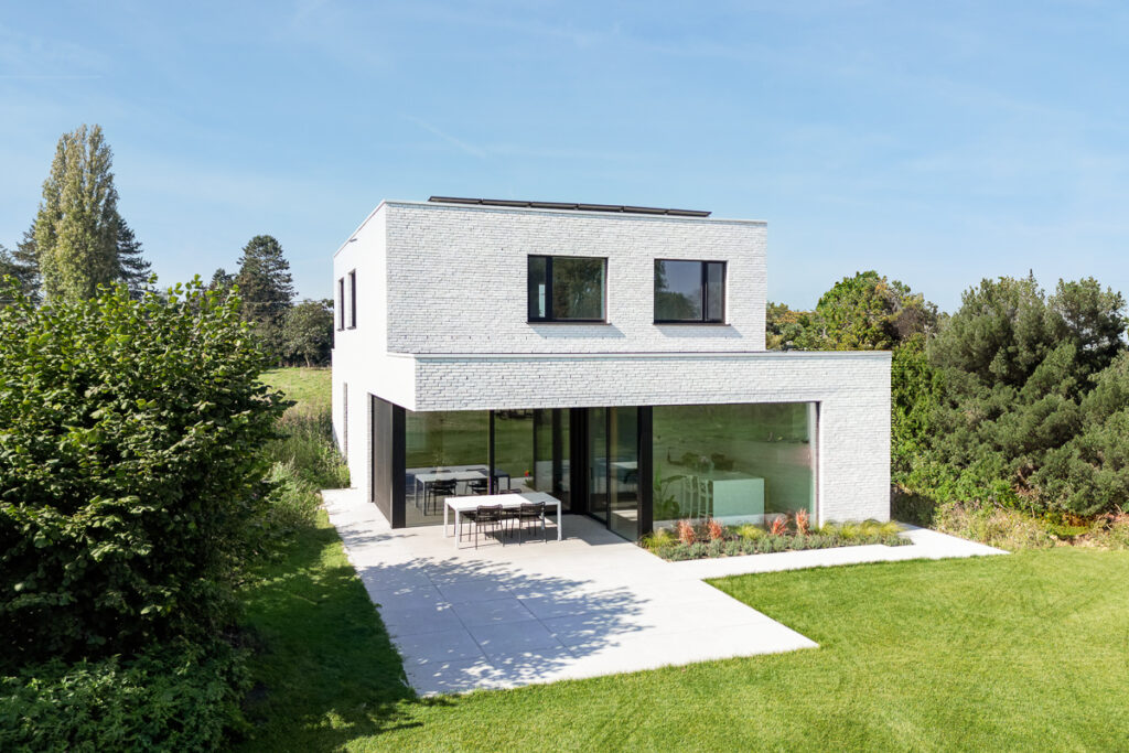 Nieuwbouwwoning in witte gevelsteen met grote glaspartijen, klaar voor de oplevering door Sito Architecten.